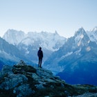 A hiker standing in the mountains above Chamonix in early morning light..