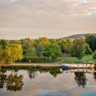 Boat on the Yonne river with reflections at sunset near Joigny  in Burgundy, France.