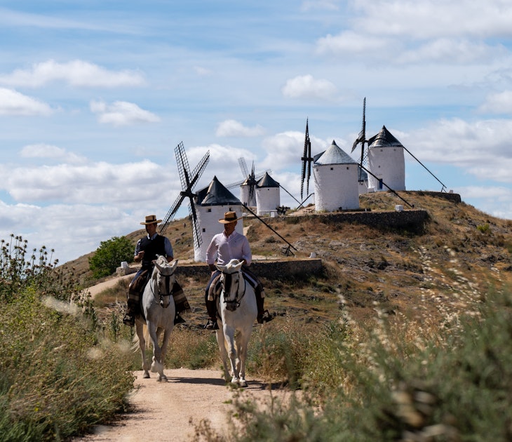 May 16, 2024: We started the day at the Centro Ecuestre Los Caireles.  There we met our hosts Miguel Angel and his brother Jesus, who own and run the farm.  (Miguel Angel wore a black vest.)  The Centro is a horse back riding school.  We shot pics at their farm and then headed to the town of Consuegra.  On the mountain overlooking the town, there is a castle and several windmills.  We shot pics and video of Miguel Angel and Jesus riding around the windmills and the castle.  This area is notable because it is where the fictional Don Quixote rode around in Miguel de Cervantes’ famous novel.  Afterward, we returned back to El Centro where we filmed our hosts riding by grape vineyards and olive groves to the nearby Villafranca de los Caballeros lagoons.
Spain Marketing 1379722