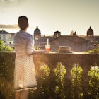 Young woman tourist fashion white dress with spritz cocktail in front of panoramic view of Rome cityscape from campidoglio terrace at sunset. Landmarks, domes of Rome, Italy.
1207032121