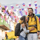 A man and woman embracing and laughing as they walk along a city street in Colombia