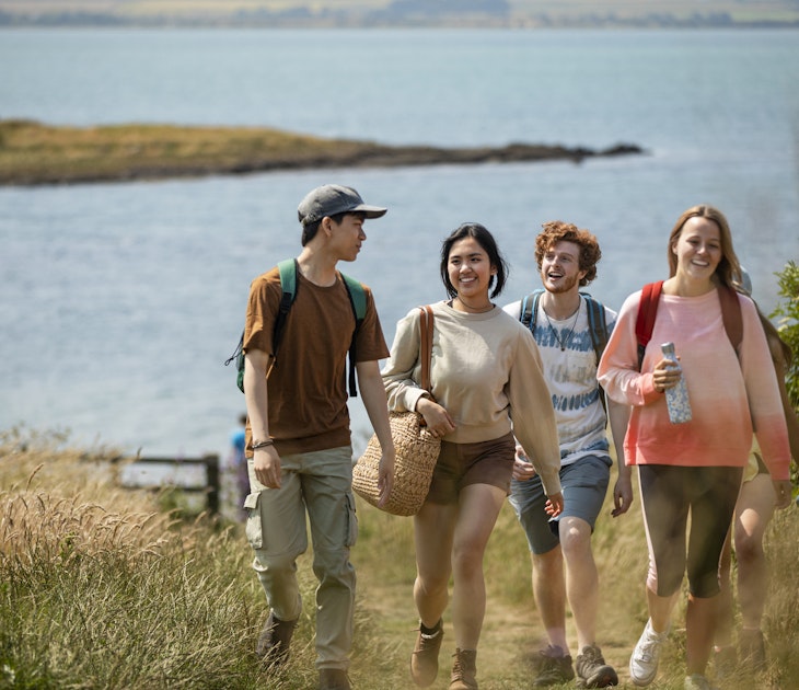 Wide angle shot of a group of mixed ethnic teens on a walk along the coastline together at Holy Island in the North East of England in summer.
1398830993