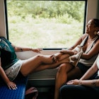 Three friends on a train laughing