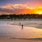 456482477
Colourful setting sun at Wells-Next-the-sea on the North Norfolk coast.  Image shows people walking along the waters edge of an incoming tide starting to cover up the beach with the beach huts and forest in the background.
Colourful setting sun at Wells-Next-the-sea on the North Norfolk coast. Image shows people walking along the waters edge of an incoming tide starting to cover up the beach with the beach huts and forest in the background.