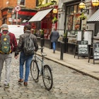 Mixed race gay men with bicycles in the city in the Temple Bar district of Dublin, Ireland