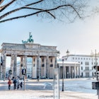 view on winterly Berlin Brandenburger Tor in morning sun
638326526
Capital Cities, Tourism, Paris Platz, Quadriga Statue - Brandenburg Gate, Color Image, Walking, History, Cultures, Famous Place, Architecture, Travel Destinations, Outdoors, Horizontal, Tourist, People, Brandenburg Gate, Berlin, Germany, Europe, Tree, Sunlight, Day, Winter, Sun, Snow, Sign, Symbol, blue sky, Sunny