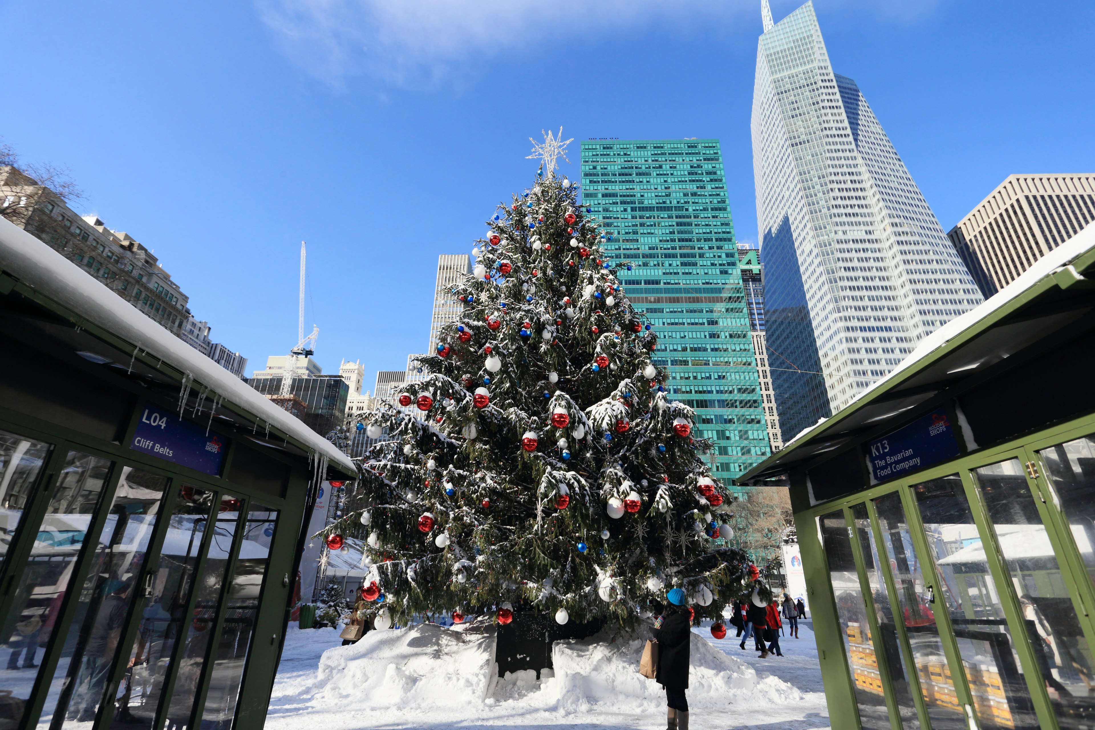 A Christmas tree surrounded by heavy snow in a high-rise city