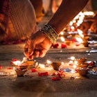 Close-up of a hand lighting incense on the ground at night in Varanasi.
758617141
Human Hand, Varanasi, Color Image, Focus, Celebration, India, Real People, Adults Only, Illumination, Photography, Image Focus Technique, People, Part Of, One Woman Only, Horizontal, Holding, Only Women, Hold, Adult, Human Body Part, Glowing, Selective Focus, Oil Lamp, Close-up, Diwali, Street, Women, Bracelet, Spirituality, Diya - Oil Lamp, Religion, Petal, One Person, Flame, Heat - Temperature, Candle, Illuminated, Lifestyles, Outdoors, Burning, Night