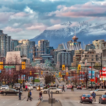 Downtown Vancouver during the day with snow-capped mountains across the strait.