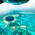 Aerial panoramic view of The Great Blue Hole - Detail of Belize coral reef from airplane excursion - Wanderlust and travel concept with nature wonders on azure vivid filter
1460271564
great