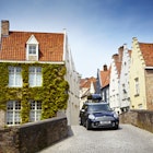 Mini driving on narrow cobbled street.