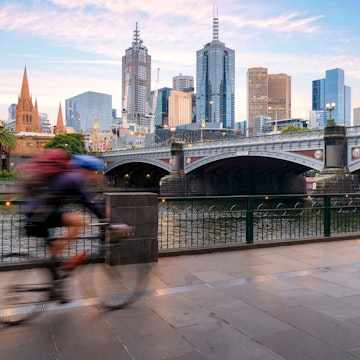 Australian people cycling  for exercise near Yarra River with view of the Melbourne City Financial District with skyscrapers in morning at Melbourne, Victoria, Australia.