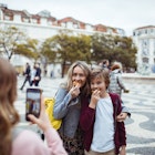 Close up of a young family taking pictures together while exploring the Rossio square in Lisbon and having Portuguese tarts