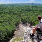 A young man with a grey backpack sitting on the top of the famous pyramid of Coba, Yucatan, Mexico. The jungle in the background reaches till the horizon. Concept of travel, nature and ancient culture; Shutterstock ID 1422642605; purchase_order:65050 - Digital Destinations and Articles ; job:Online Editorial; client:Mexico hikes; other:Tasmin Waby
1422642605