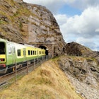 Closeup of train exiting a tunnel. View from Cliff Walk Bray to Greystones with beautiful coastline, cliffs and sea, Ireland; Shutterstock ID 1617672064; GL: 65050; netsuite: Lonely Planet Online Editorial; full: Getting around Ireland; name: Brian Healy
1617672064
beach, beautiful, bray, cliff, cliff walk, cliffs, cloudy, coast, coastal, coastline, countryside, dart, europe, exiting, exploring, green, greystones, hike, hiking, ireland, irish, landscape, motion, mountain, nature, no people, ocean, outdoor, path, railway, rocks, scenery, scenic, sea, seascape, stunning, summer, tourism, tracks, trail, train, travel, tunnel, vacation, view, walk, walkway, water, weather, wicklow