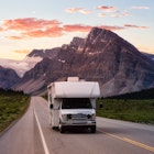 Scenic road in the Canadian Rockies during a vibrant sunny summer sunrise. White RV Driving on route. Taken in Icefields Parkway, Banff National Park, Alberta, Canada., License Type: media_digital, Download Time: 2024-08-21T21:06:05.000Z, User: bfreeman_lonelyplanet, Editorial: false, purchase_order: 65050, job: Online Editorial, client: Best places to RV , other: Bailey Freeman