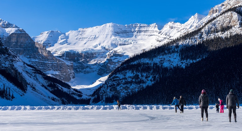 Tourists skating on Lake Louise winter ice skating rink. Banff National Park, Canadian Rockies. Alberta, Canada., License Type: media, Download Time: 2024-08-23T16:48:26.000Z, User: joe_lp, Editorial: false, purchase_order: 56530, job: Global Publishing-Wip, client: Your Ultimate Travel Adventure List, other: Joe Fullman