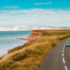 Aerial panoramic view of road with blue car on it with the Needles and sea view. The Isle of WIght, UK
2165386893