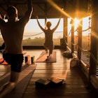 People practice yoga in an open yoga studio near the ocean while the sun sets..
1074578957
adult, balance, beautiful, blind, class, contemporary, costa rica, doing, exercise, female, fitness, group, hall, happy, healthy, hut, jungle, large, lifestyle, light, meditate, meditation, nature, open, outside, palm tree, peace, people, person, pose, position, relaxation, retreat, silhouette, sky, space, sport, studio, style, summer, sunlight, sunset, tropical, vacation, view, wellness, woman, wood, wooden, yoga