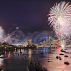 Sydney New Year eve fireworks over Harbour with bridge and city CBD buildings reflecting colourful fire balls in blurred water.
407263750
downtown, skyscraper, pyrotechnics, arch, australia, fun, display, firework, illuminated, ball, wide, urban, flash, landmark, bright, show, night, celebration, light, event, yacht, nye, blurred, dark, elevated, entertainment, reflection, city, color, towers, crowd, sydney, water, bridge, eve, cityscape, nsw, harbour, new, family, berrys, bay, year