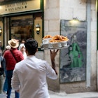 APRIL 29, 2024: Chocolatería San Ginés is a popular restaurant in Madrid for churros and chocolate. It's been servicing customers since 1894. Here, waiters prepare and bring diners their churros. 

Spain Marketing 1379722