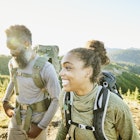 Father and daughter smiling as they hike together in a park