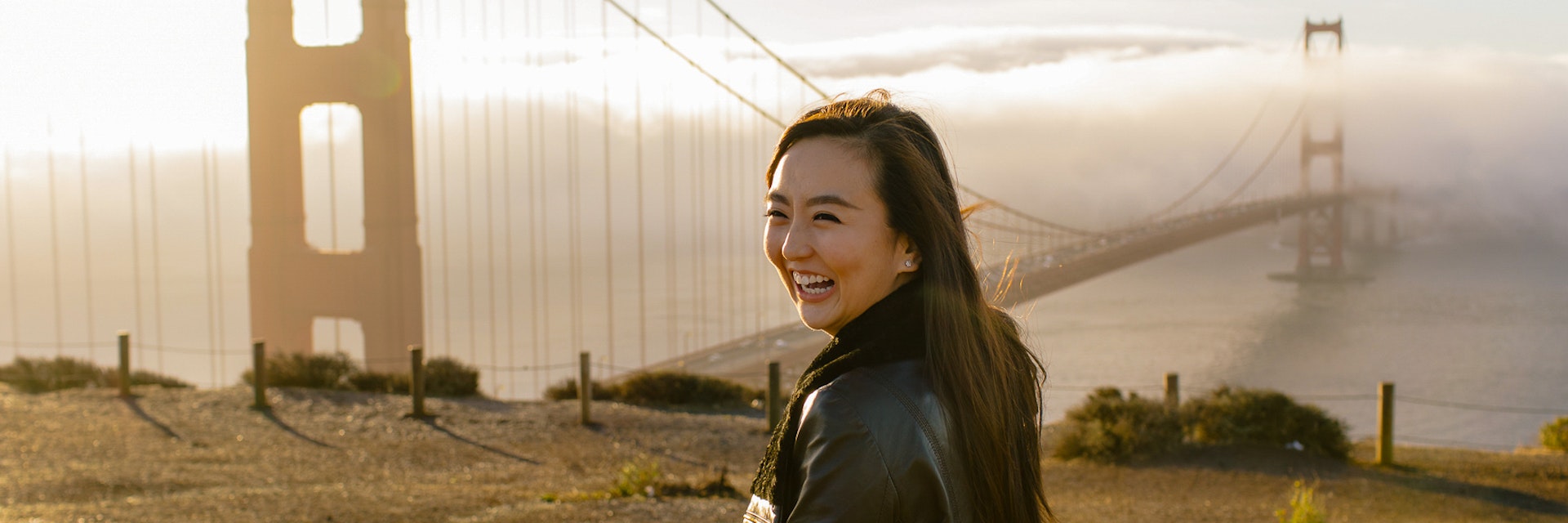 Woman in front of Golden Gate Bridge at sunrise in San Francisco